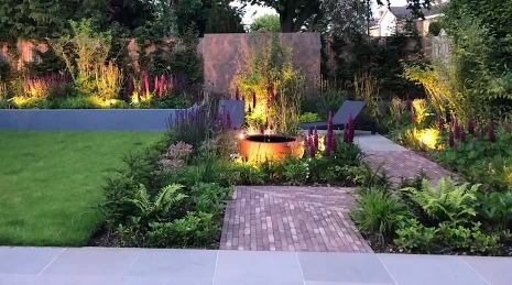 Landscape lighting along a garden path and patio at night