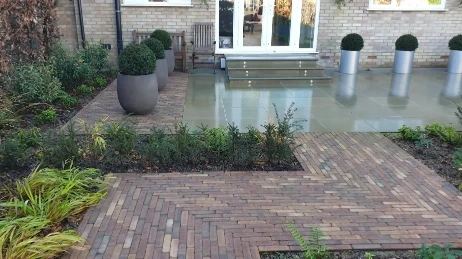 Paver patio and hardscaping installation by Las Cruces landscapers, with planters and a brick walkway