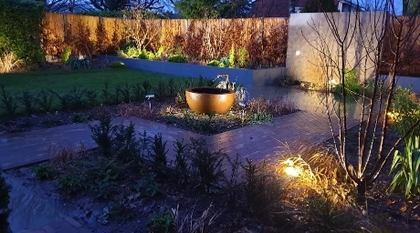 Weed control Las Cruces NM - clean, weed-free planting beds and garden path in a landscaped yard at dusk