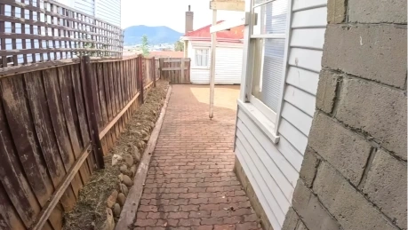 Drainage solutions Las Cruces NM - side yard with paver walkway and rock drainage strip along the fence