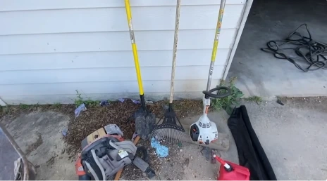 Landscaping tools set out on a patio before a rock bed refresh